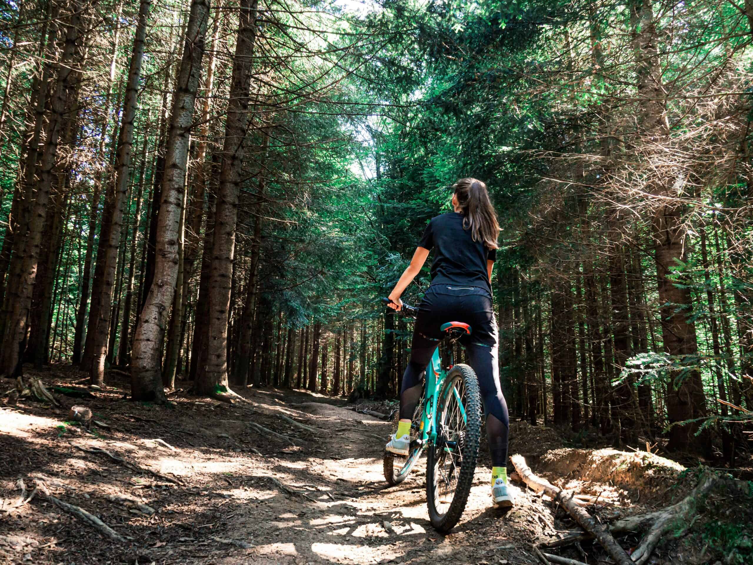 Person riding a mountain bike through a forest trail in Kitimat.